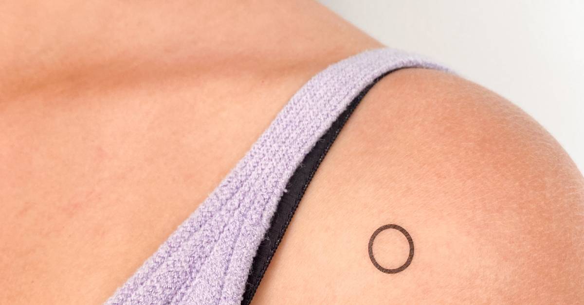 Minimalistic little circle temporary tattoo located on