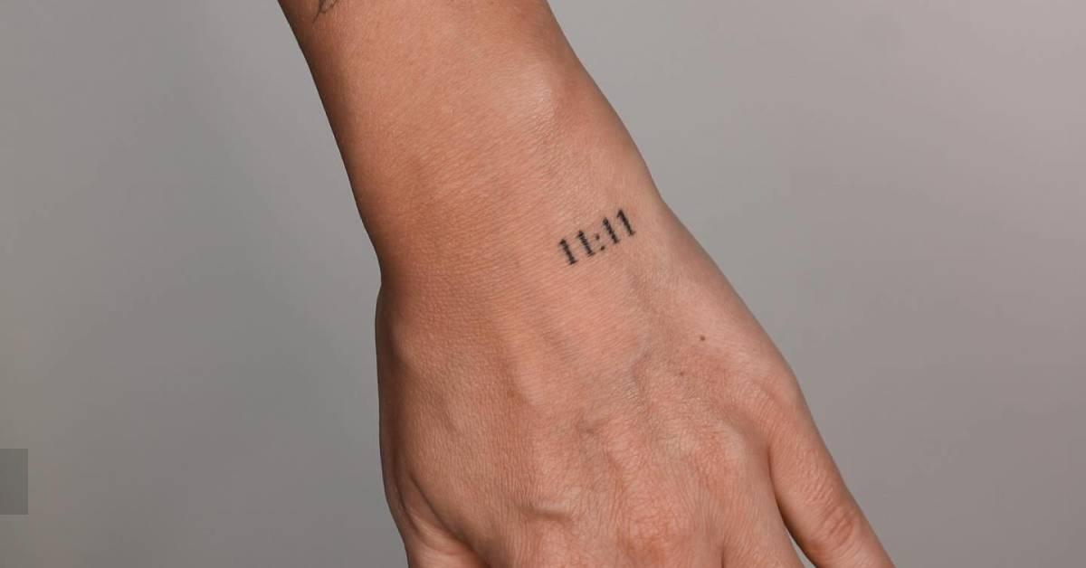 Angel number "11:11" tattoo located on the hand.