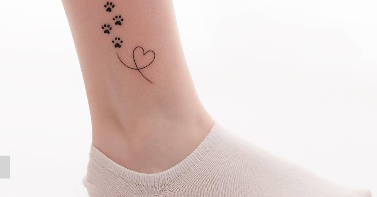 Minimalistic style paws and heart tattoo located on the