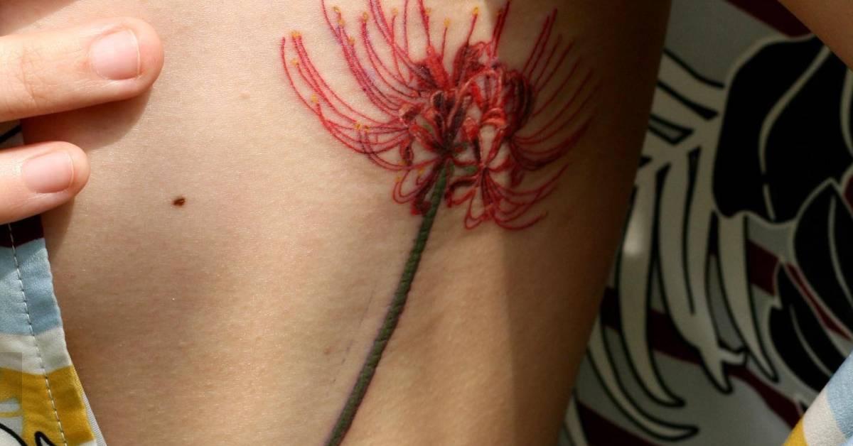 Red spider lily tattoo located on the side boob,