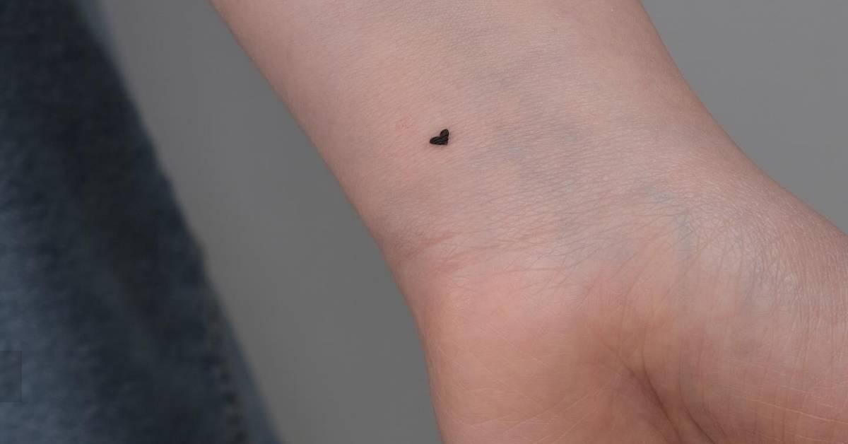 Tiny minimalistic heart tattoo placed on the wrist.