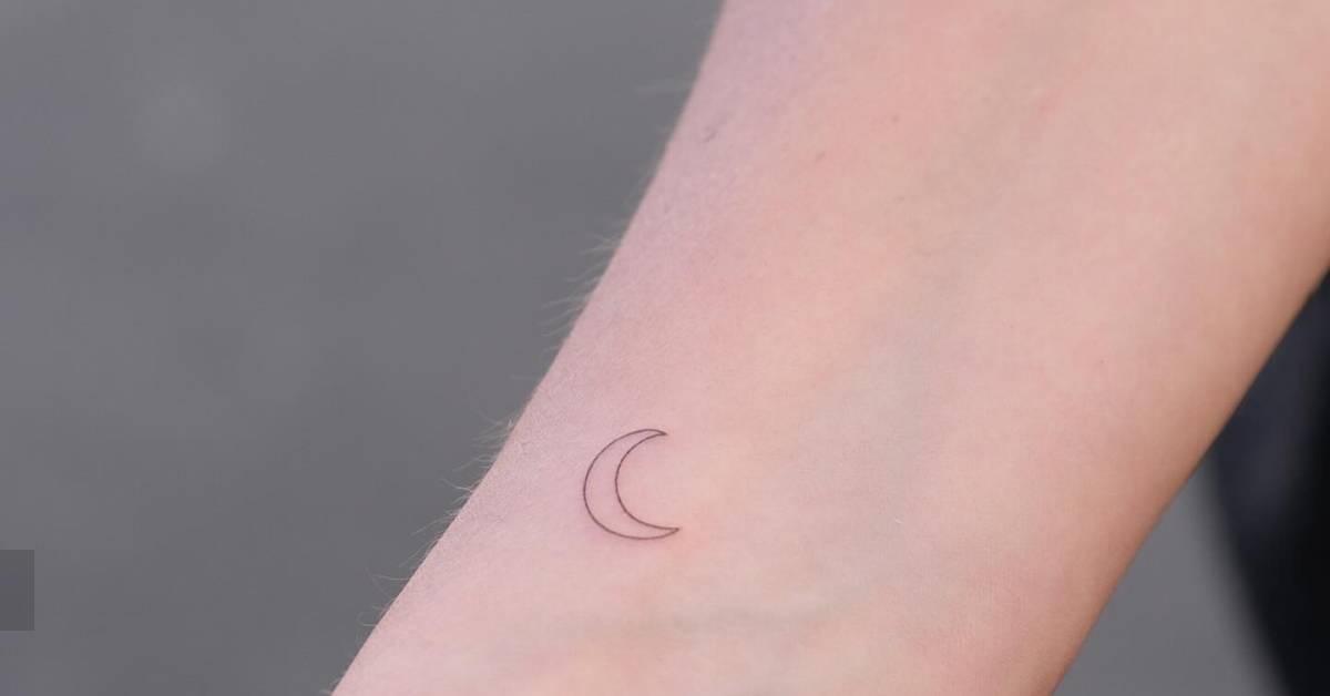 Minimalistic style crescent moon tattoo placed on the