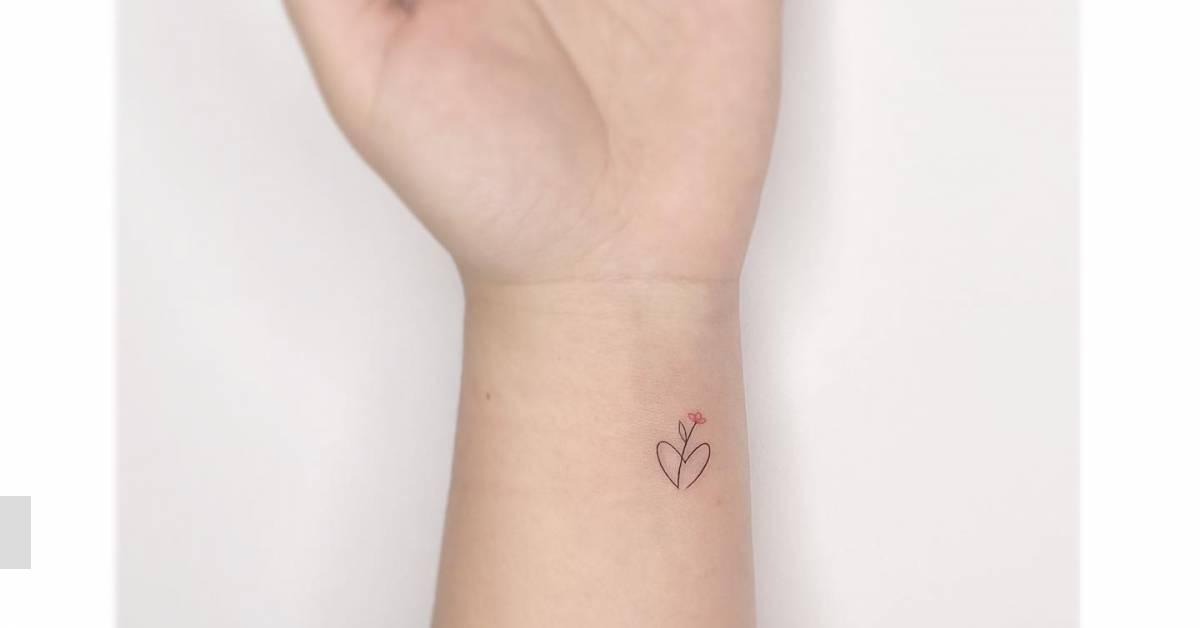 Minimalistic style flower and heart tattoo located on