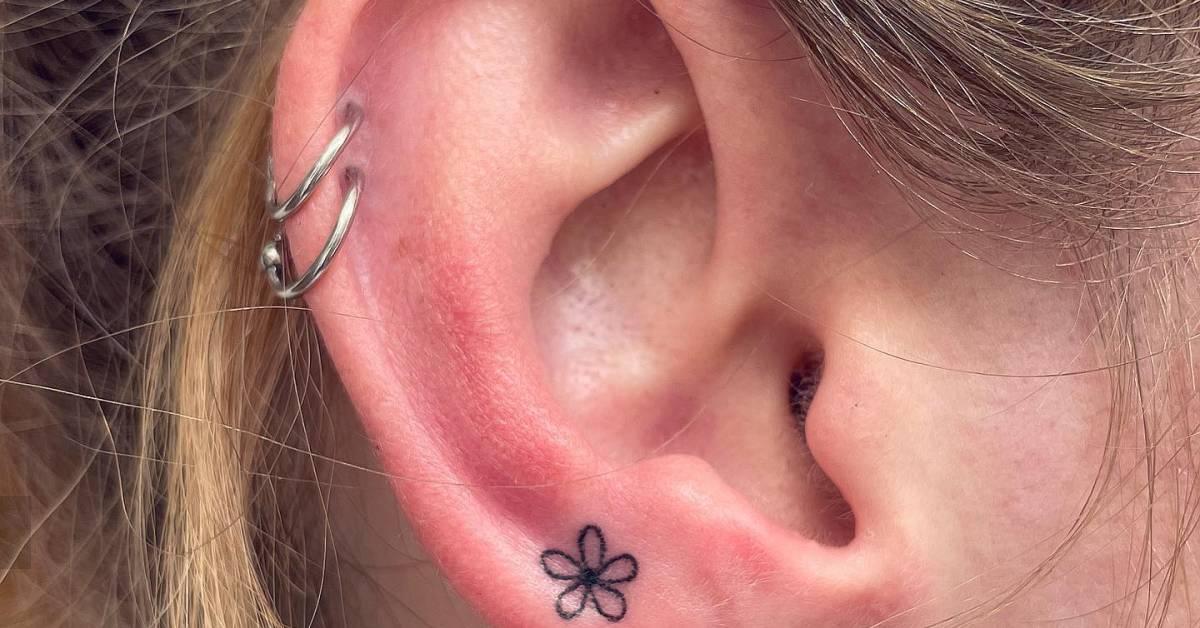 Minimalistic hand poked flower tattoo located on the
