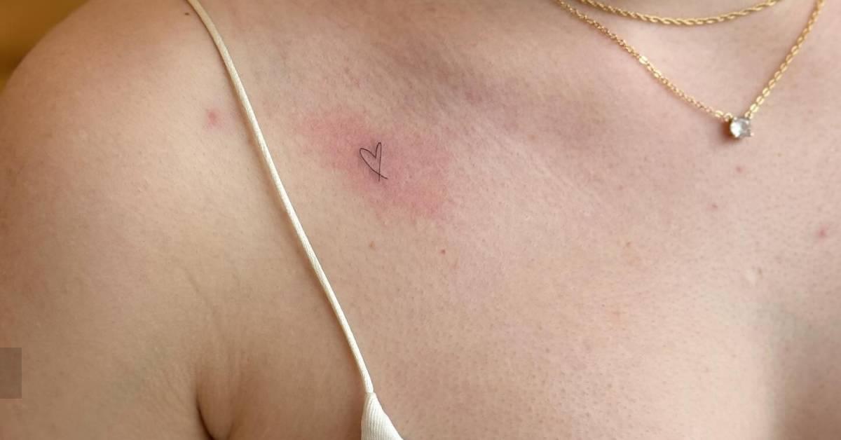 Tiny minimalistic heart tattoo located on the