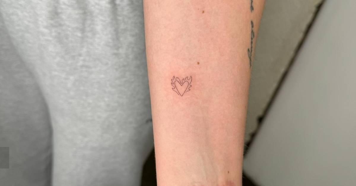 Minimalistic style flaming heart tattoo located on the