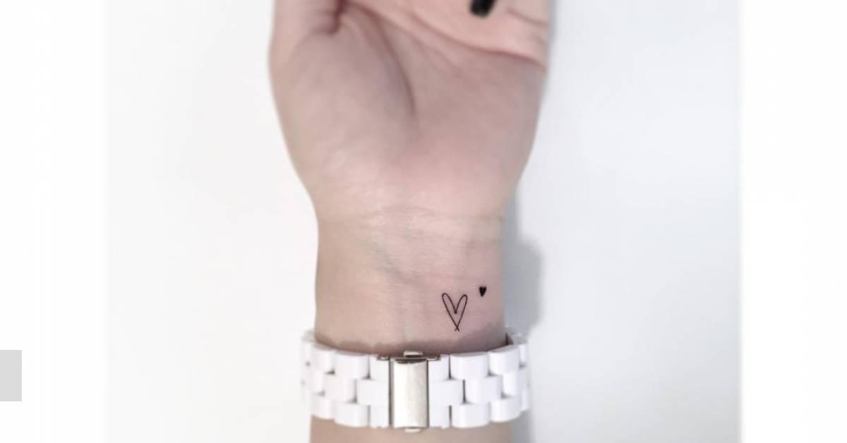 Minimalistic style heart tattoo located on the wrist.