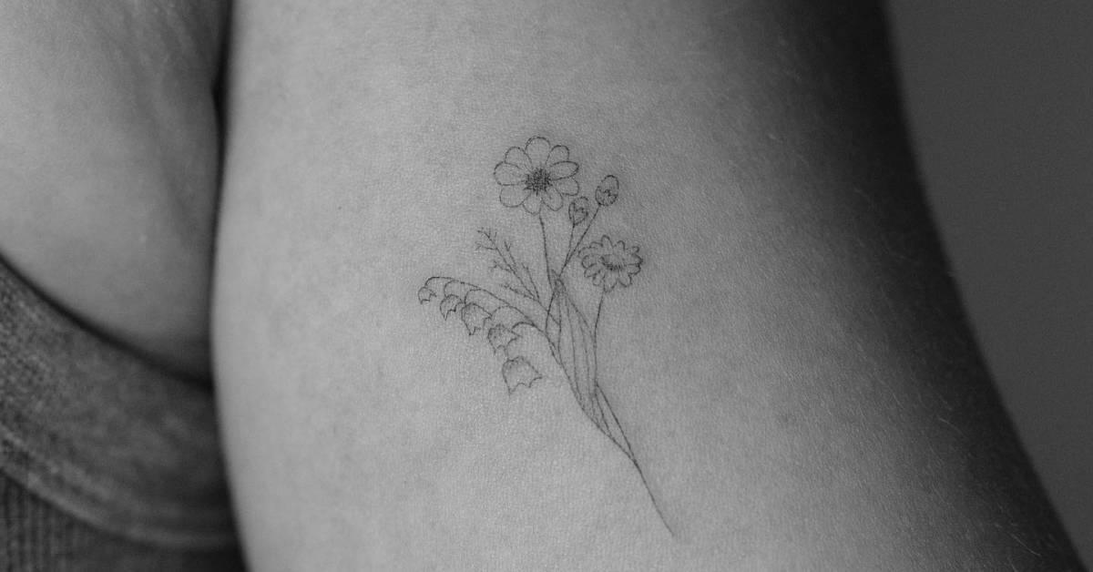 Fine line style flower bouquet tattoo located on the