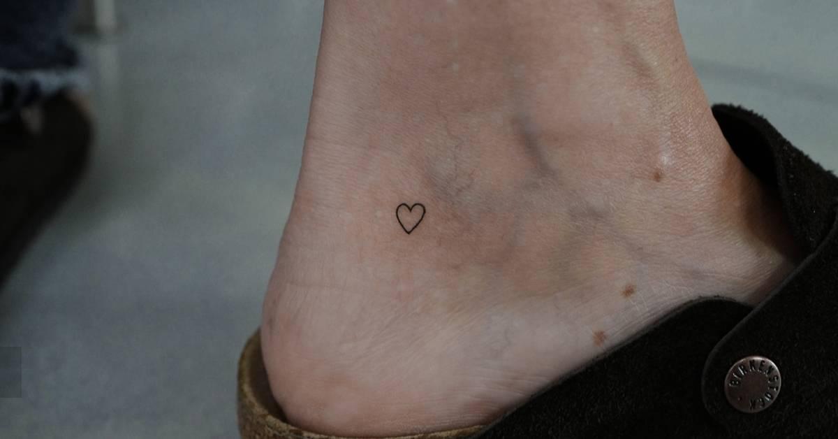 Tiny minimalistic heart tattoo located on the ankle.