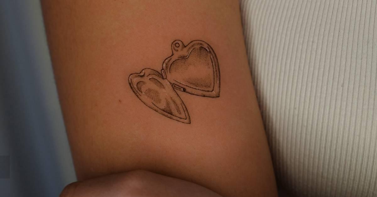 Illustrative style heart pendant tattoo located on the