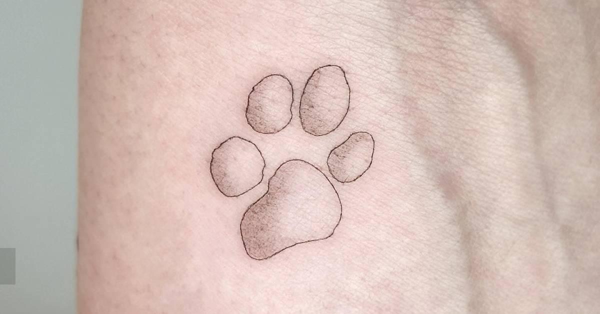 Minimalistic style dog paw print tattoo located on the