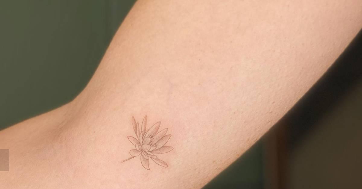 Lotus flower tattoo in fine line style located on the