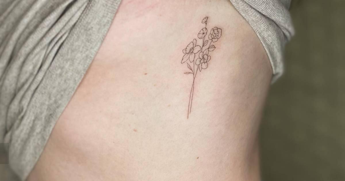 Fine line style flower bouquet tattoo placed on the