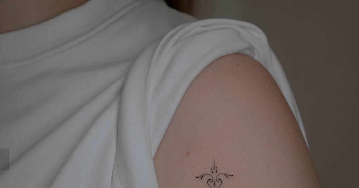 Fine line style ornamental tattoo placed on the upper