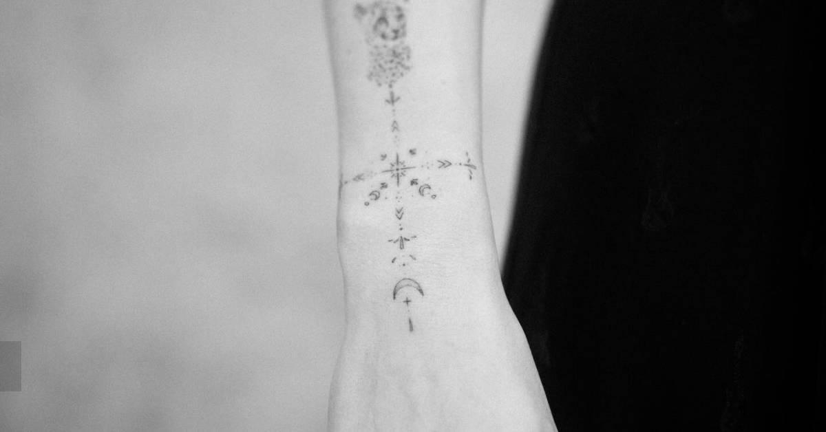 Fine line style ornamental tattoo located on the wrist.