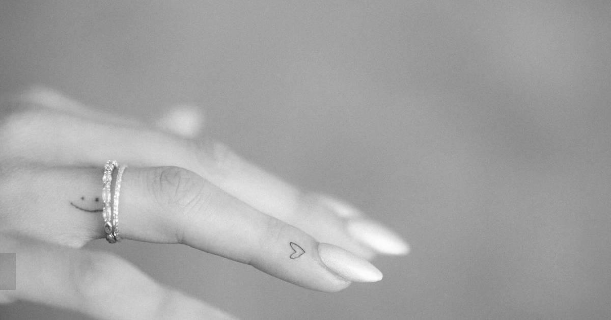 Tiny minimalistic heart tattoo located on the finger.