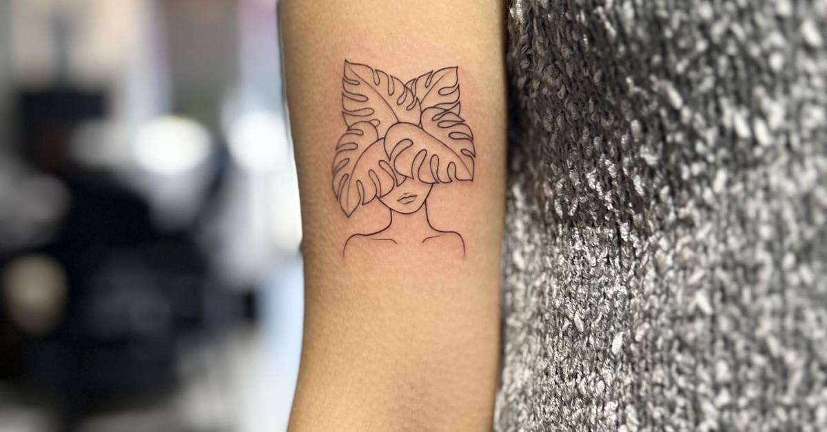Flower head woman tattoo located on the bicep, fine
