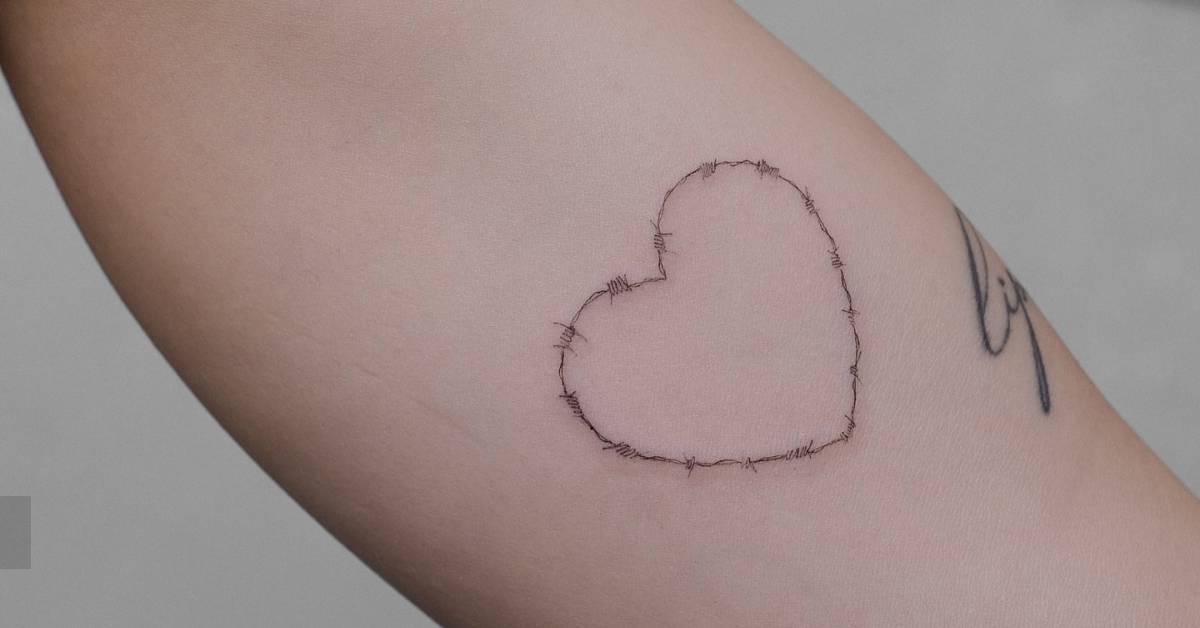 Barbed wire heart tattoo located on the inner arm.