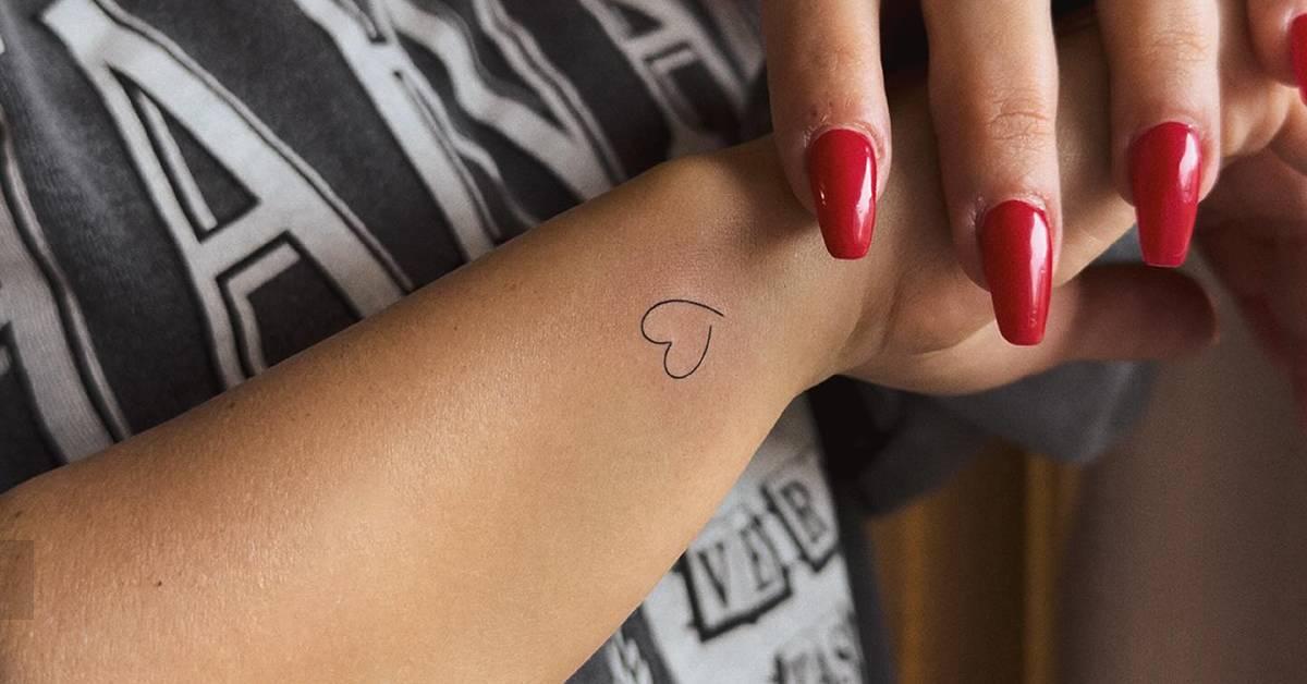 Minimalistic style heart tattoo placed on the wrist.