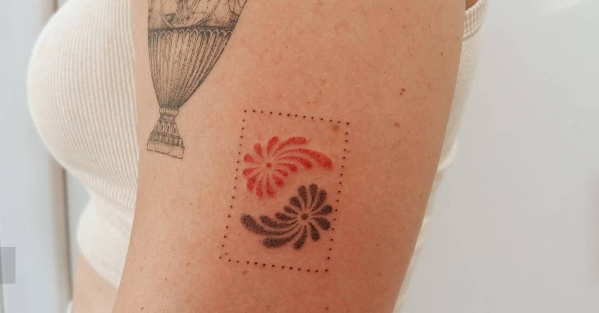 Yin Yang ornaments tattoo hand poked on the upper arm.