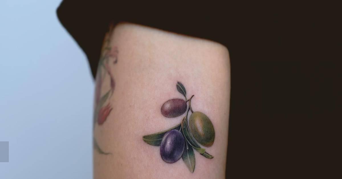 Micro-realistic style olive branch tattoo located on