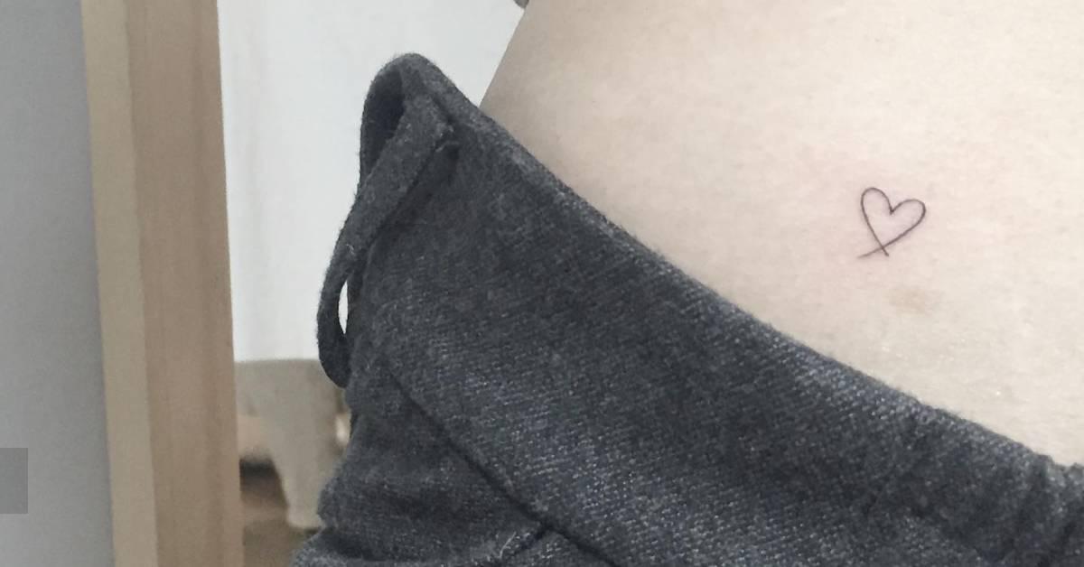 Tiny minimalistic style heart tattoo located on the