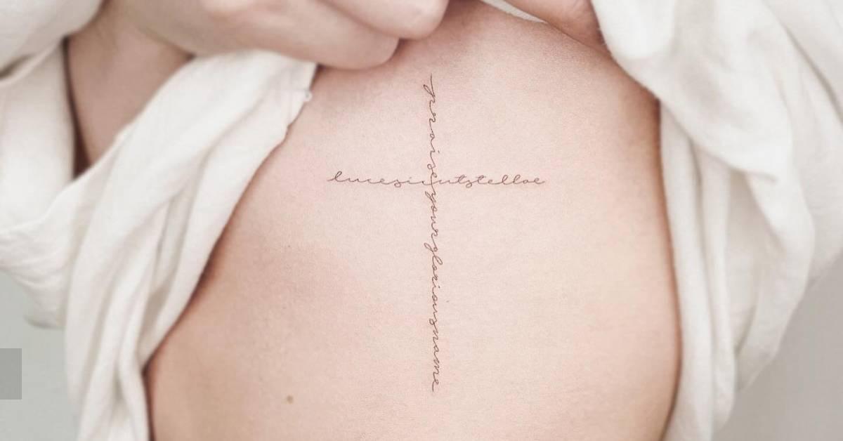 Handwritten font lettering cross tattoo located on the