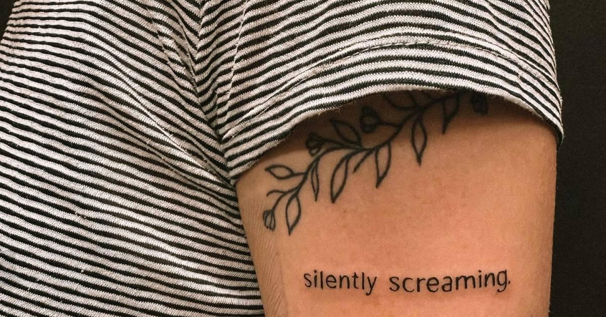 Lettering tattoo that says "silently screaming" placed