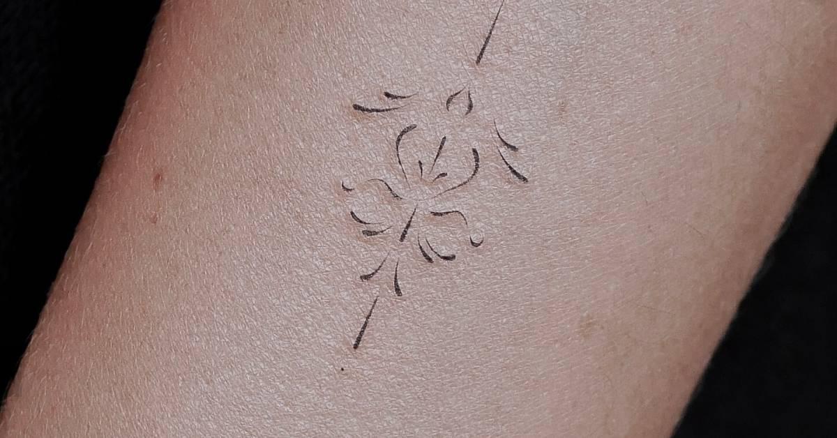 Fine line style ornamental tattoo located on the