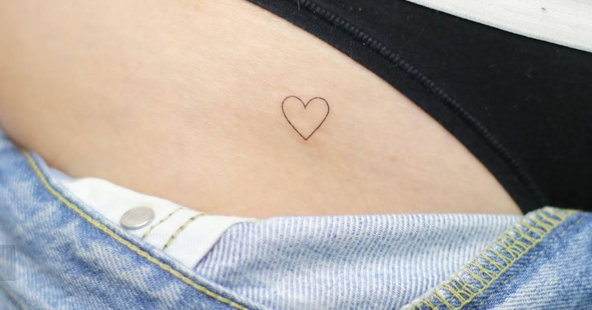 Minimalistic style heart tattoo located on the pelvis.