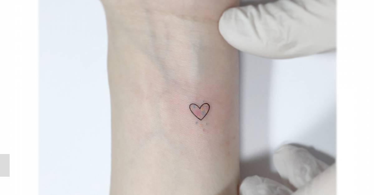 Minimalistic style heart tattoo located on the wrist.
