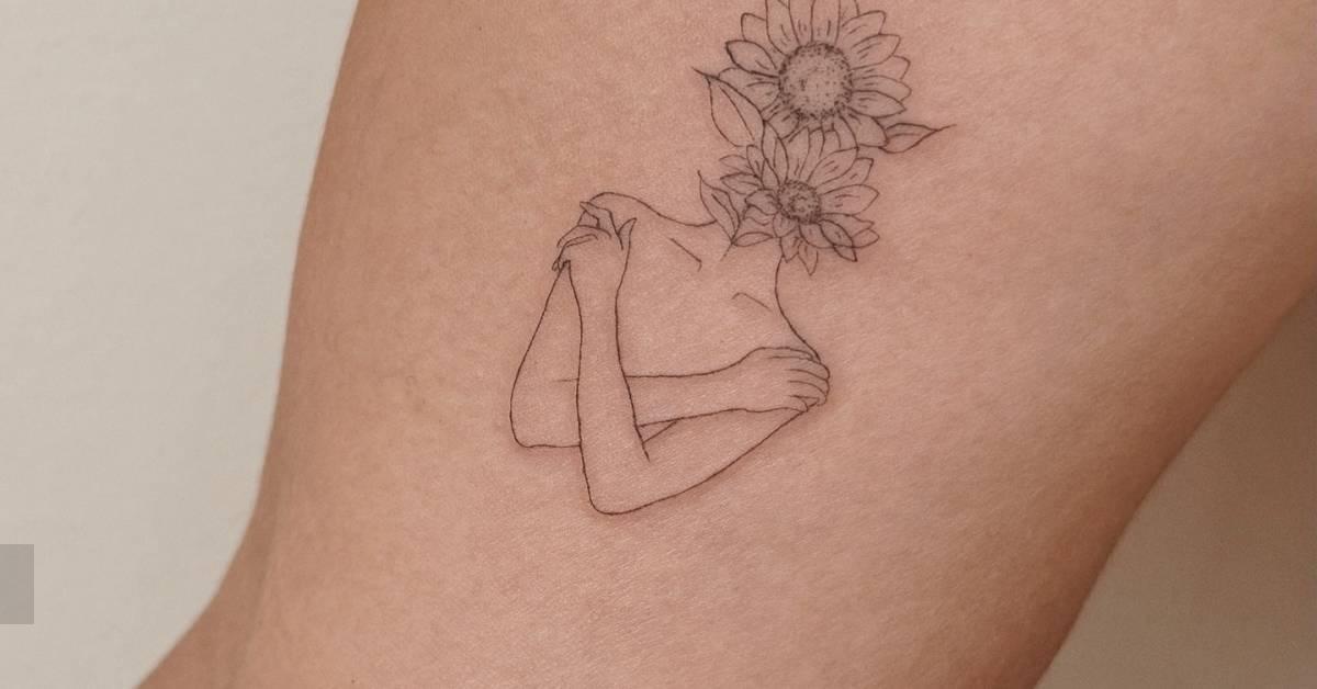 Flower head woman tattoo located on the inner arm, done