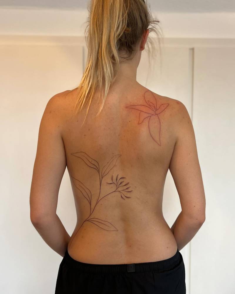 Hand poked line art style flowers tattoo located on the back.