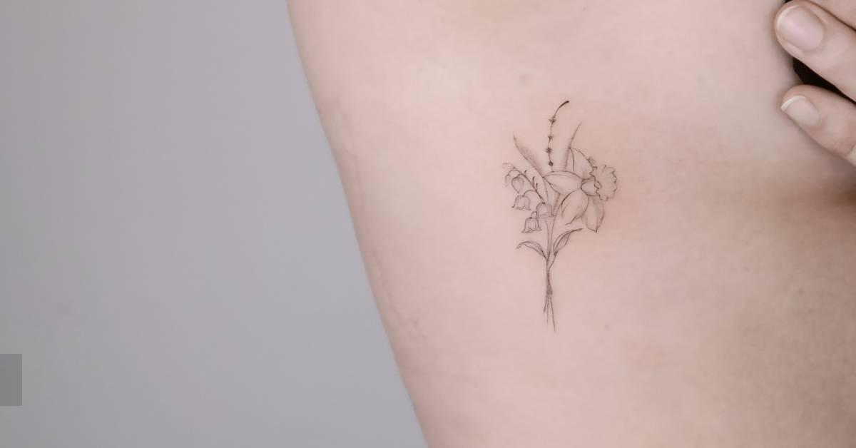 Fine line style flower bouquet tattoo located on the
