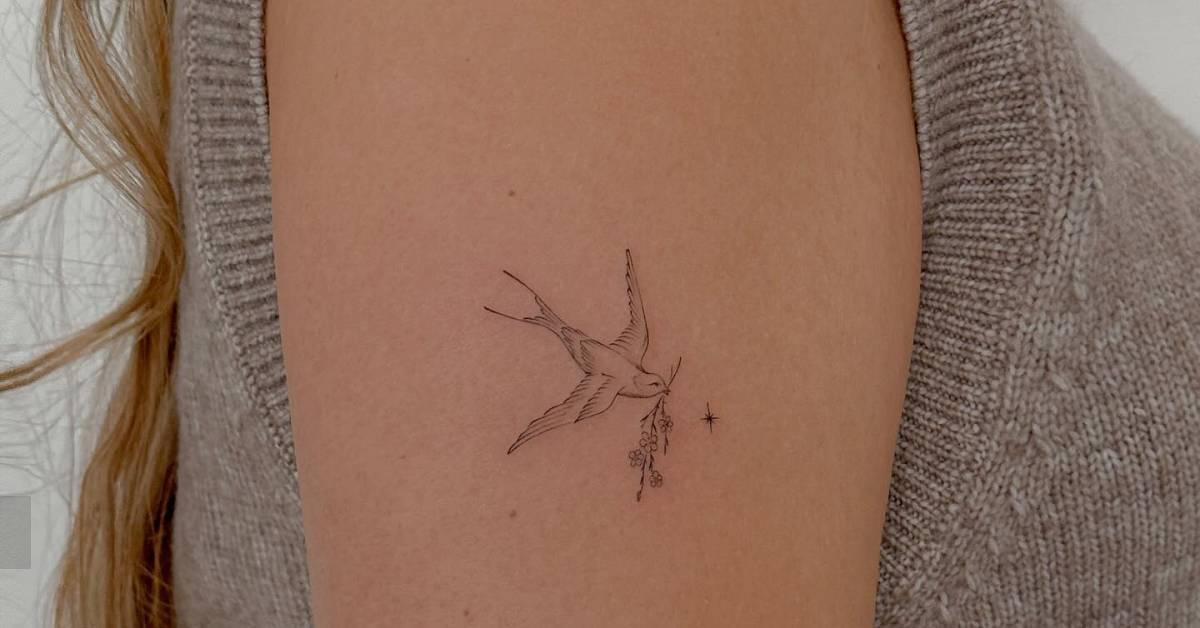 Swallow tattoo done on the upper arm, fine line style.