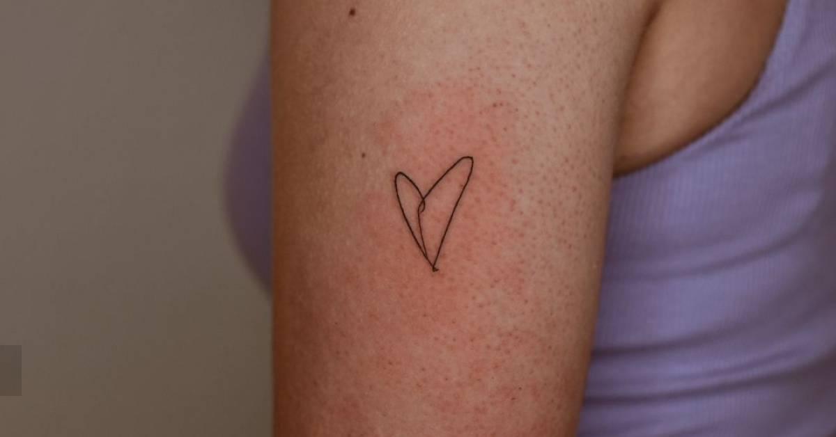 Minimalistic style heart tattoo located on the upper