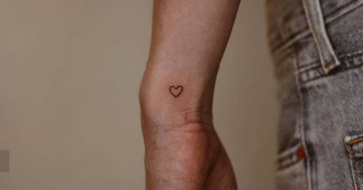 Tiny minimalistic heart tattoo located on the wrist.