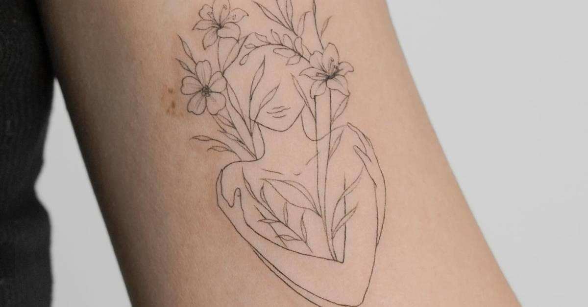 Flower head woman tattoo in fine line style located on