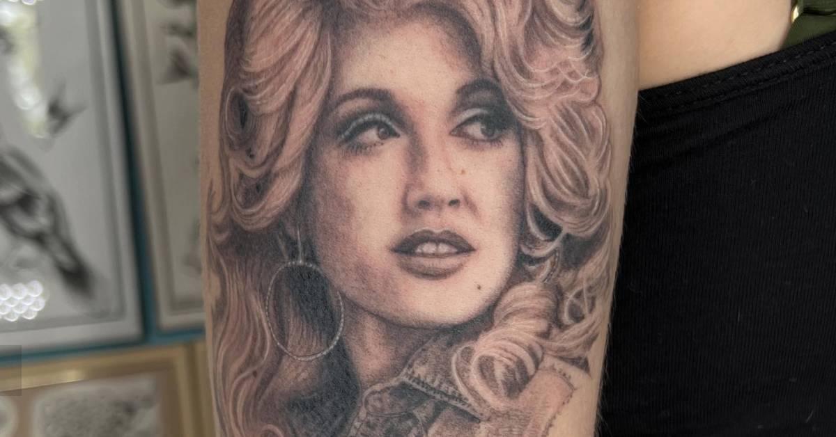 Black and grey dolly parton portrait tattoo located on