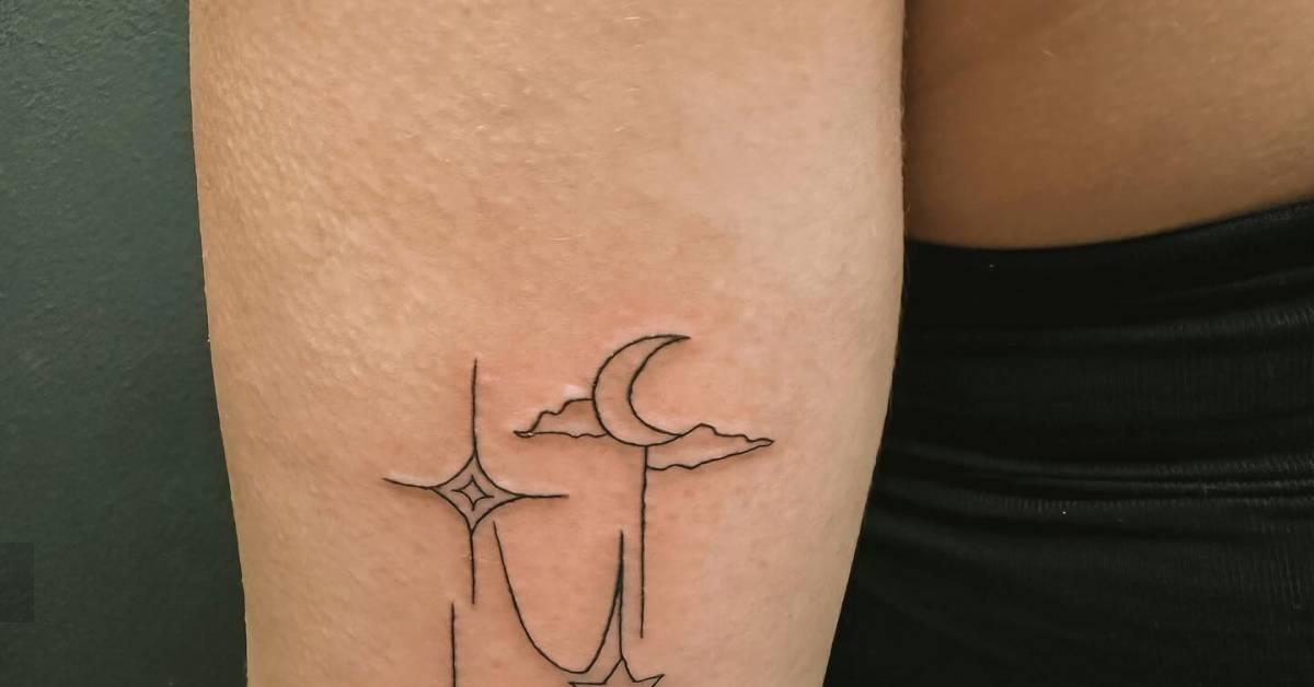 Fine line style sun, moon and stars tattoo located on
