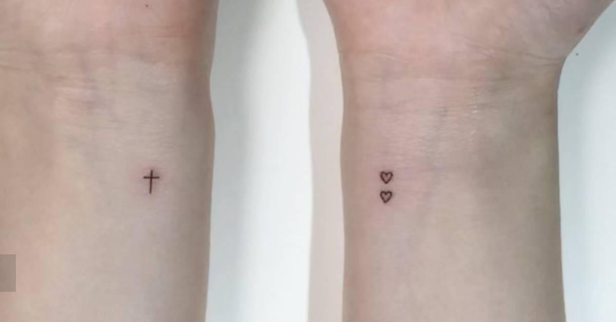 Minimalistic style cross and hearts tattooed on the