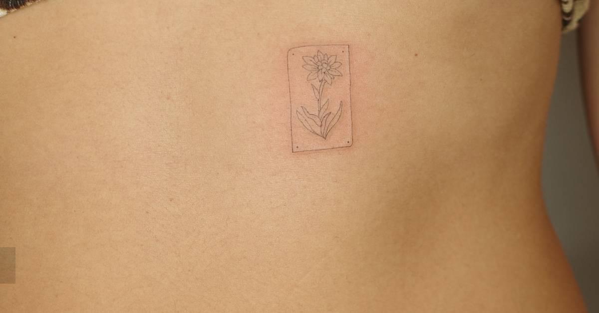 Fine line style daffodil tattoo placed on the rib.