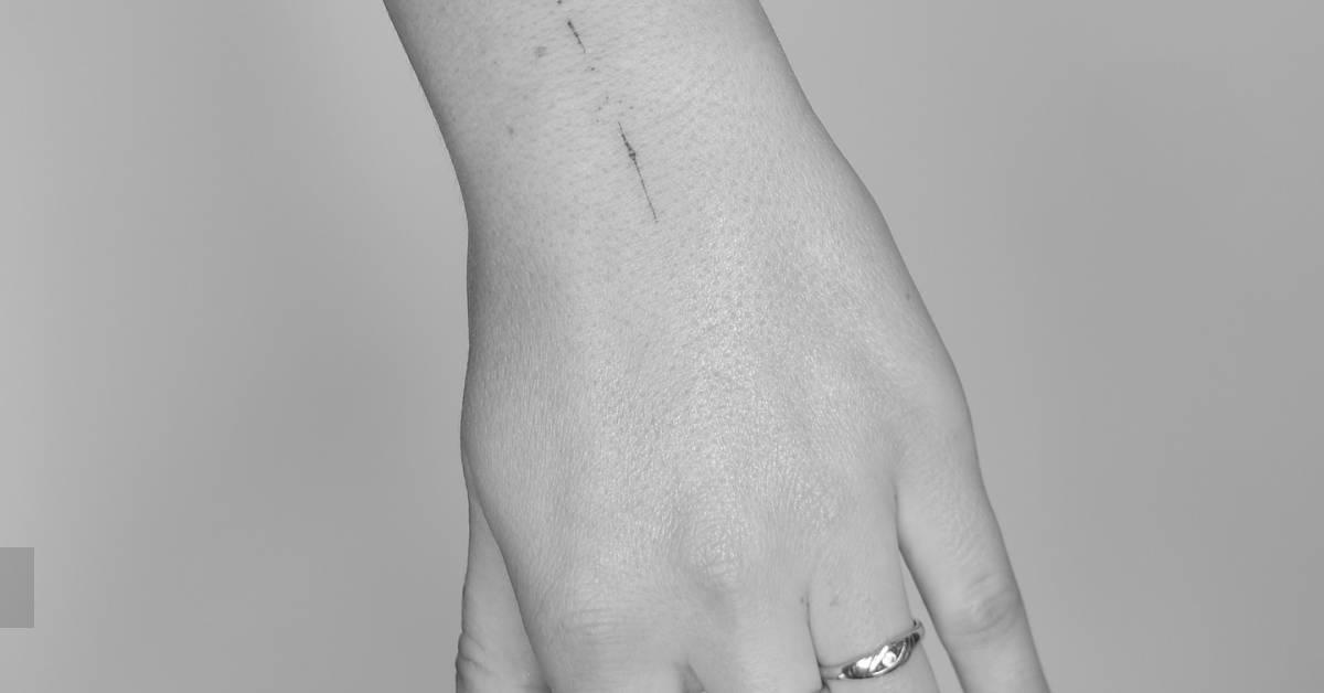 Fine line style ornamental tattoo located on the wrist.