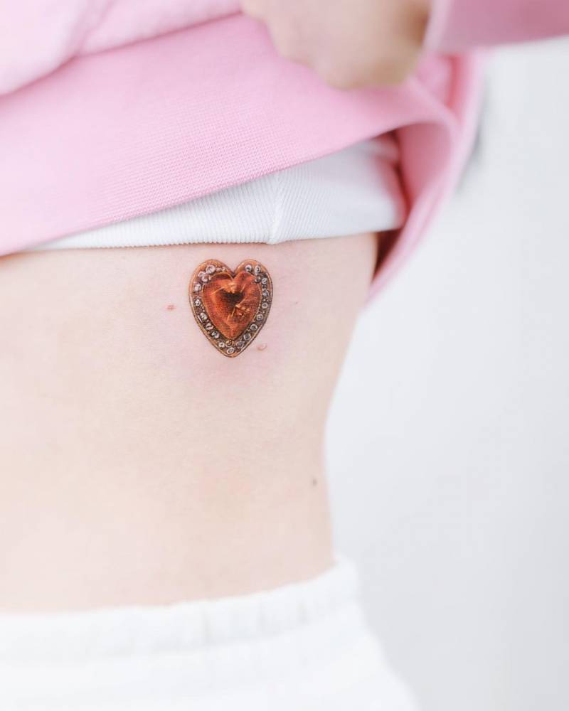 Her mom's wedding pendant tattooed on the rib.