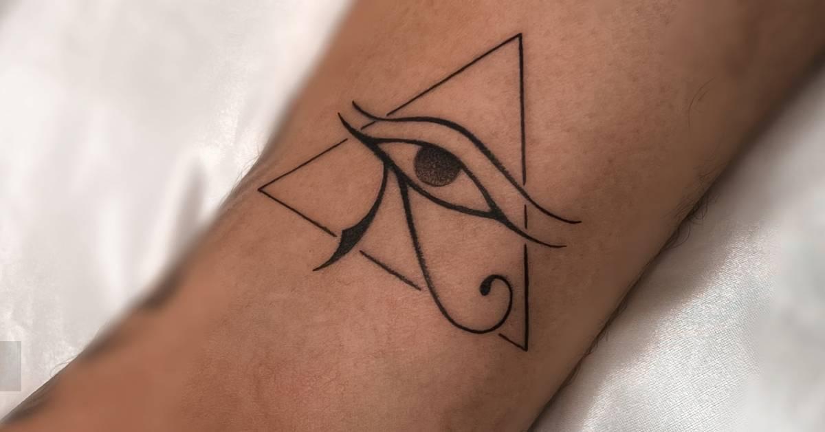 Eye of Horus and triangle tattoo located on the ankle.
