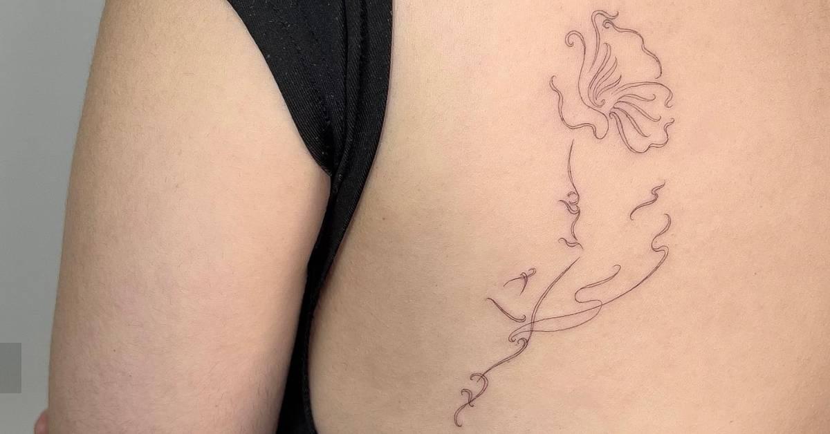 Fine line style flower head woman tattoo located on the