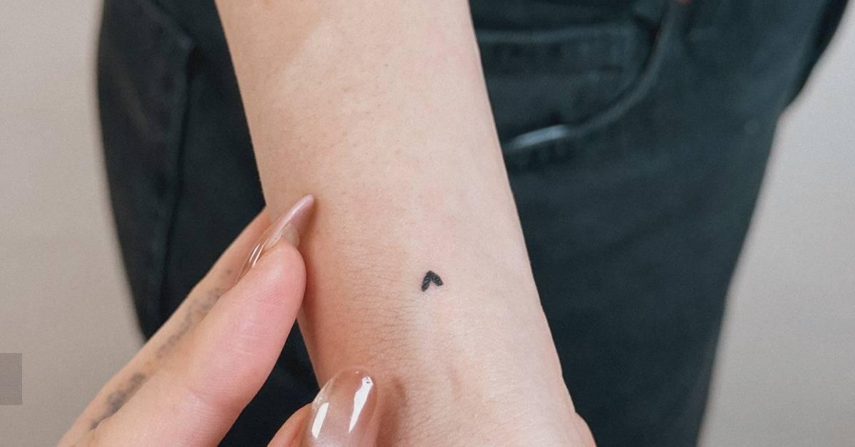 Little heart tattoo in minimalistic style located on