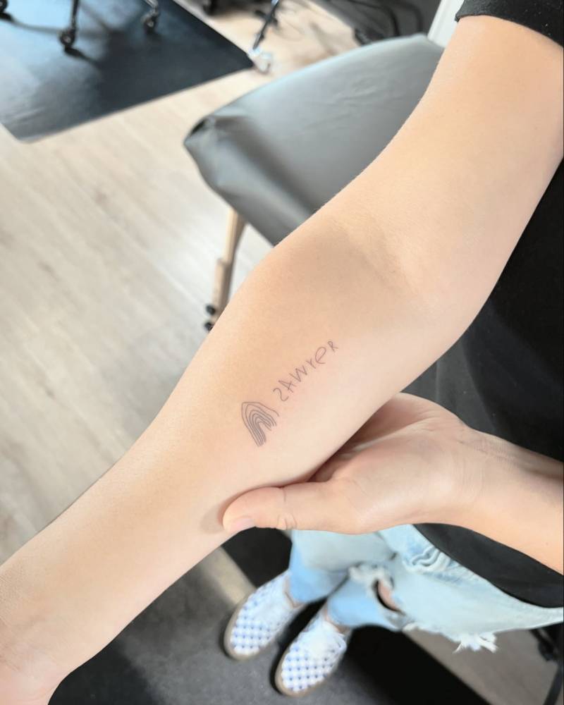 Child's drawing tattoo located on the inner forearm.