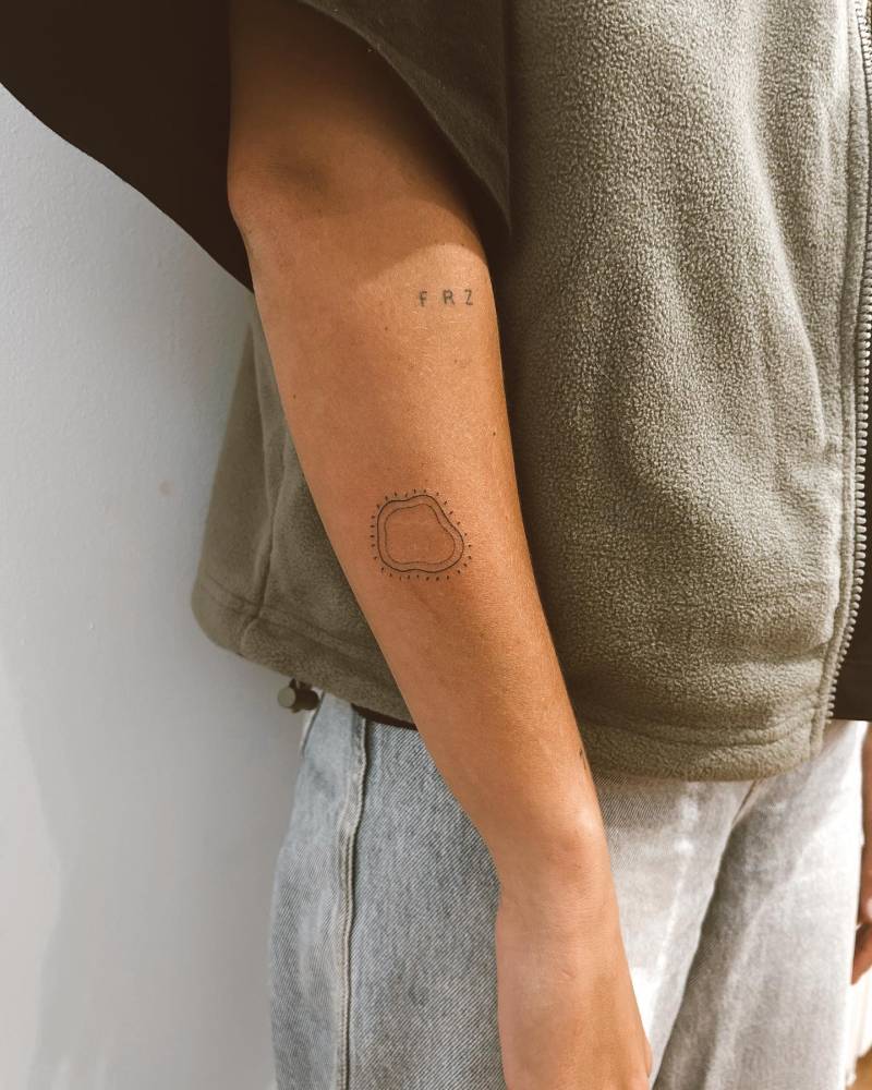 Hand poked abstract tattoo in fine line style located on the forearm.