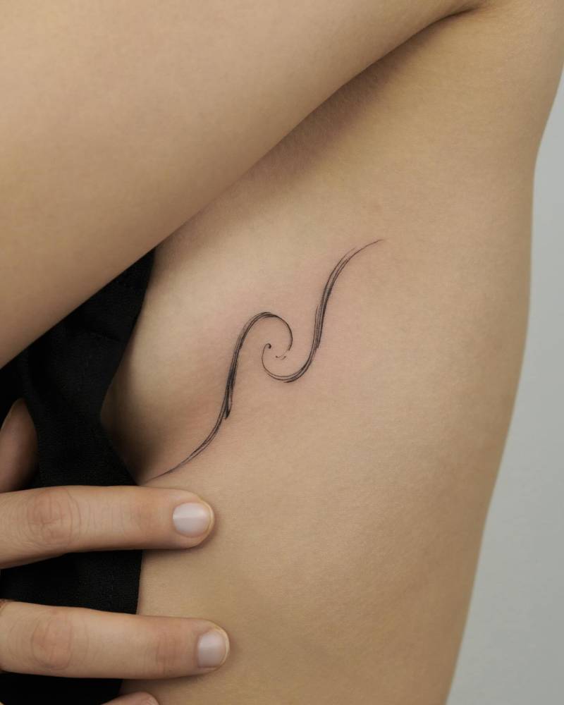 Sketch work style wave tattoo located on the side boob.